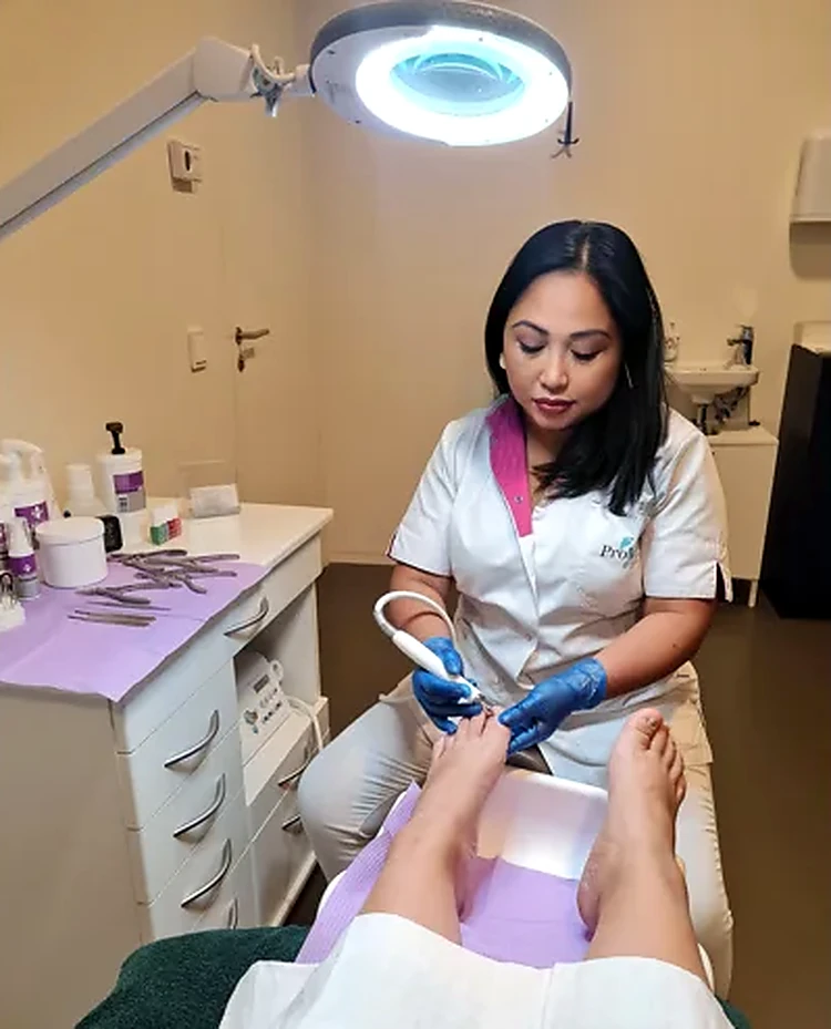 MaryJay verzorgt de voeten van een cliënt in de pedicurepraktijk
